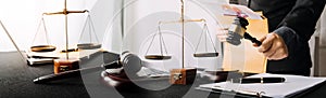 Close up gavel on white desk with Male judge reading legal books background.justice and law concept