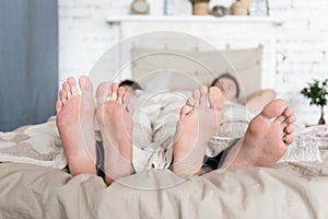 Close up of gay couples feet lying in bed