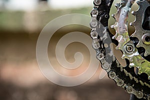 Close-up of gears and a chain to drive a bicycle. The chain is dirty and greasy. Copy space