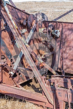 Close up of gears on vintage pull-type combine abandoned in a field in Saskatchewan, Canada