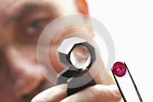 Close up of gemstone with jeweler looking through magnifying glass