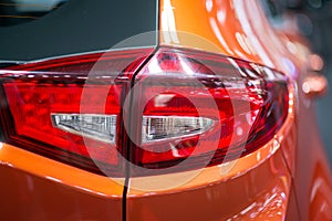 Close-up on generic rear light of a car on red