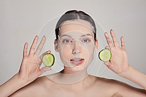 Close up gentle sophisticated calm girl in a moisturizing mask with a fresh cucumber on the face