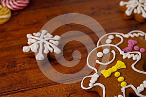 Close-up of gingerbread men with colorful icing on a wooden background with gingerbread and caramels in the background