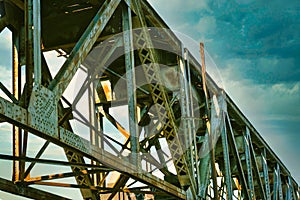 A close up of girders under a railroad trestle.