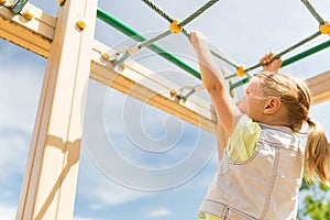 Close up of girl climbing on children playground