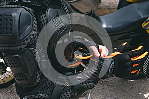 Close up of girl dressed in protective suit of body armor, tutle prtotective jacket, with glowes. Adventure motorcycle and