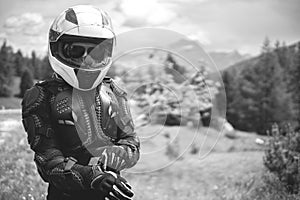 Close up of girl dressed in protective suit of body armor, tutle prtotective jacket, with helmet and glowes. Mountains view on