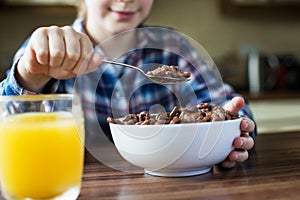Close Up Of Girl Eating Bowl Of Sugary Breakfast Cereal In Kitchen