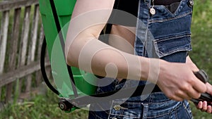 Close-up of girl farmer treats the lawn with fertilizer.