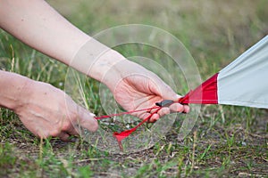 Close-up of Girl hands fastens a tent for camping pegs.