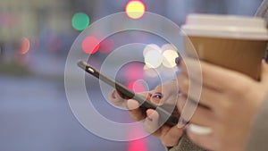 Close up of girl hands with smartphone in the city.