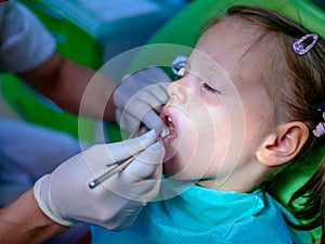Close up of girl having his teeth examined by a dentist