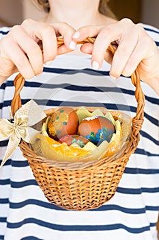 Close up girl holding colorful Easter eggs in a basket