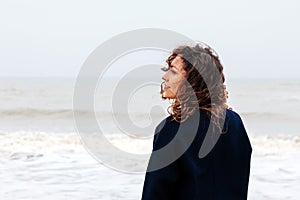 Girl rain sea wind winter portrait woman smile spring coat long hair curly mood shore snow beach