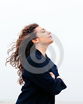 Girl rain sea wind winter portrait woman smile spring coat long hair curly mood shore snow beach