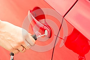 Close-up, the girl opens the door of a red car