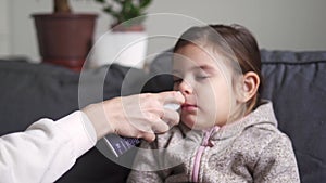 Close up of girl portrait with nose spay treatment of adenoids.