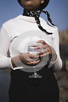 Close up of a girl`s hand holding a wine glass wearing a white sweater