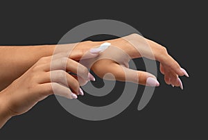 Close-up of the girl`s hands, the girl applies a cream for moisturizing and care for her hands