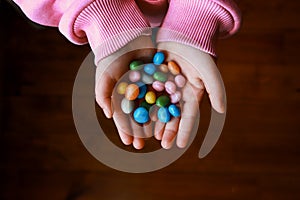 Bunch of candies in child`s hands