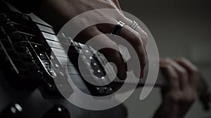 Close-up of girl\'s hands in rings play melody on black electric guitar.Solo performance of an artist,rock performer.