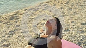 Close-up of a girl in a swimsuit relaxing and sunbathing on the ocean shore