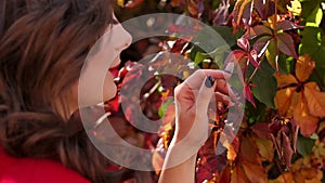 Close-up of a girl walking in autumn park on the background of autumn leaves.