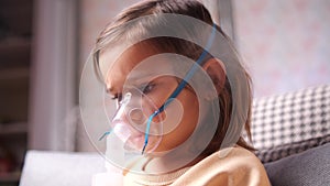 close-up of girl wearing nebulizer mask, inhaler. Girl inhales medication vapor