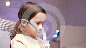 close-up of girl wearing nebulizer mask, inhaler. Girl inhales medication vapor