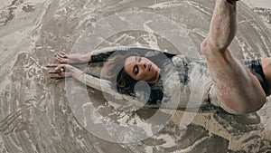 Close up, of a girl who performs modern dance on the floor with white powder or flour. Dancer young woman dancing in