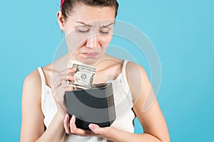 Close-up of a girl who puts or takes dollars out of a piggy bank box