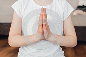 Close-up of the girl& x27;s hands folded for prayer. Relaxation and yoga practice for kids