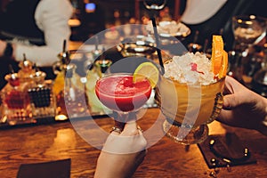 Close up of girls drinking cocktails in nightclub. Girls having good time,cheering and drinking cold cocktails, enjoying