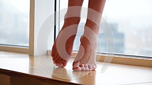 Close-up, girls feet stepping on the windowsill