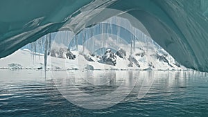 Close up glacier arch turquoise water of Southern Ocean aerial. Climate change with melting snow, ice