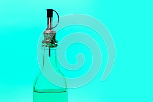 Close-up of glass bottle on background of cyan color.