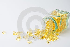 Close-up of glass bottle lying down with evening primrose oil pills, on white background with pills,