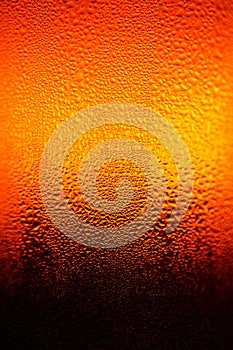 A close-up glass bottle with water condensation. Beer bottle macro image. Water droplets on the glass