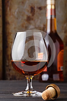 Close up of glass cognac or whiskey on rusty background