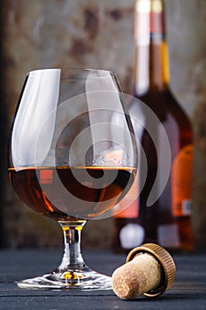 Close up of glass cognac or whiskey on rusty background