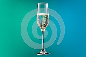 Close-up glass with cold champagne with bubbles isolated over gradient blue and green color background in neon. Concept