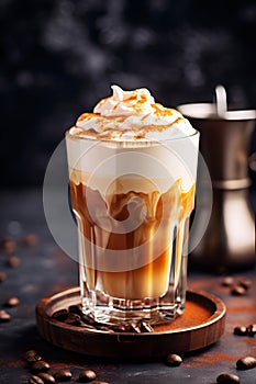 Close-up of a glass of Dalgona Coffee with cinnamon on dark background, vertical image of homemade coffee drink. Coffee latte made