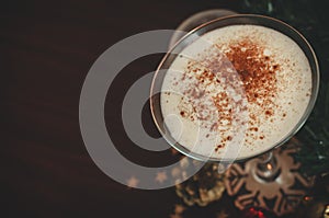 A close-up glass of eggnog on the wooden table horizontal christmas background with copy space