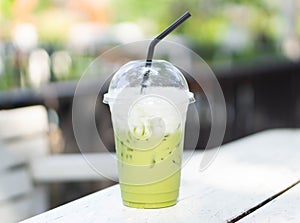 Close up glass of ice matcha green tea on wood table, selective focus