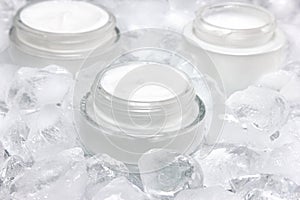 Close-up of glass jar with cream surrounded by ice cubes