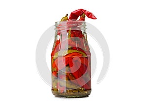A close-up of a glass jar full of red pickled chili pepper isolated on a white background. Food concept. Copy space.