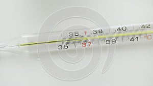 A close-up of a glass mercury thermometer shows a low temperature