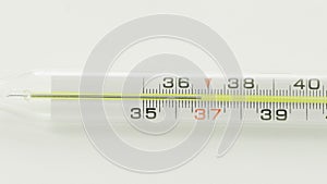 A close-up of a glass mercury thermometer shows a low temperature