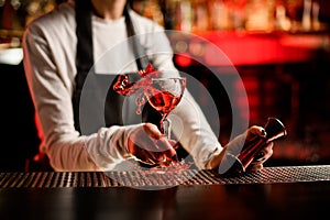 Close-up of glass with splashing cocktail decorated with flower on bar counter